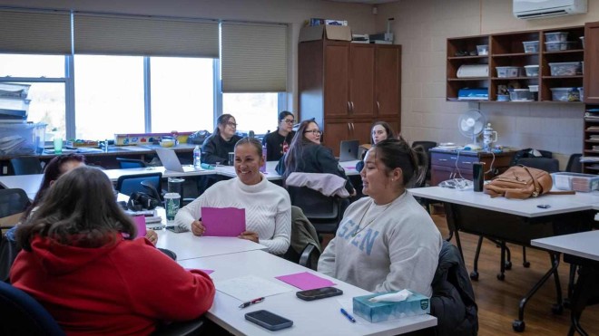 groups sit at tables, engaged in the Paswe'aatigook Anishinaabemowin Language Immersion program