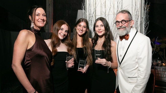 Three students in black dresses hold their PAVE awards as they celebrate with two representatives from the Hershey Company