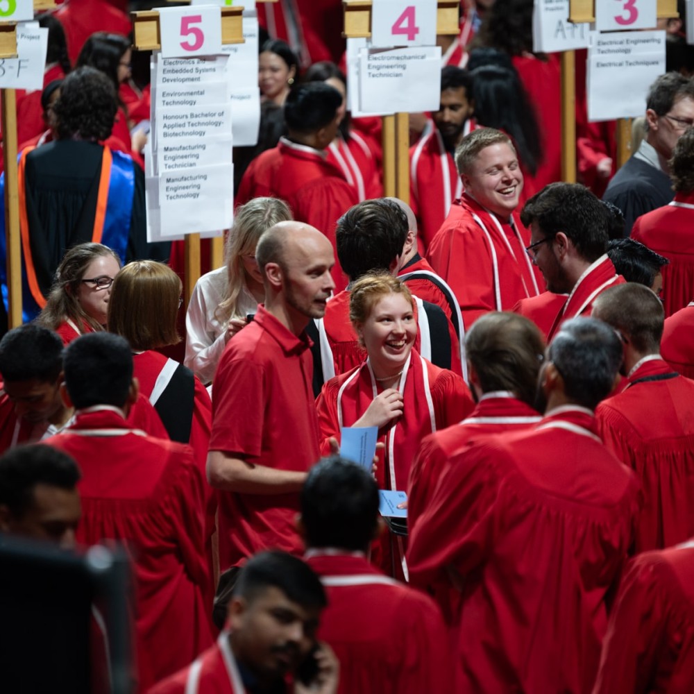 Graduates organize themselves by signage at convocation