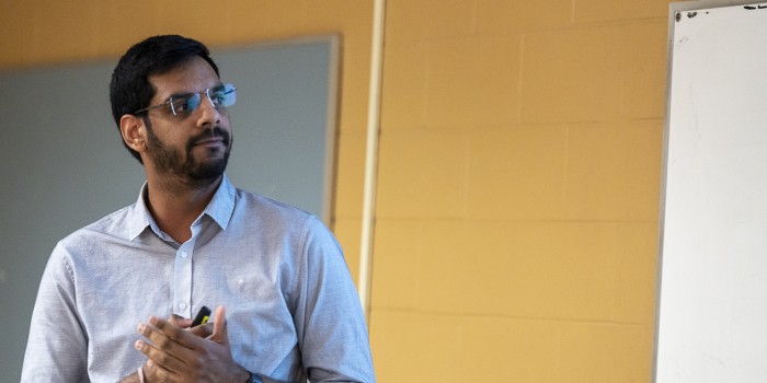 A male Indian student presenting in class.