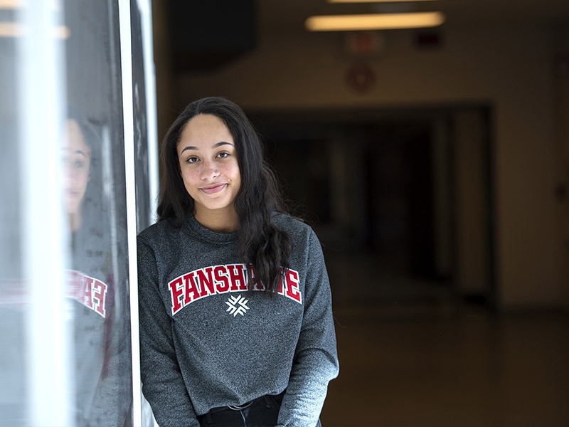 A student looks at the camera while leaning in the hallway at Fanshawe College