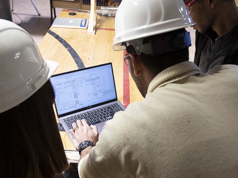 Building Technology students over a laptop