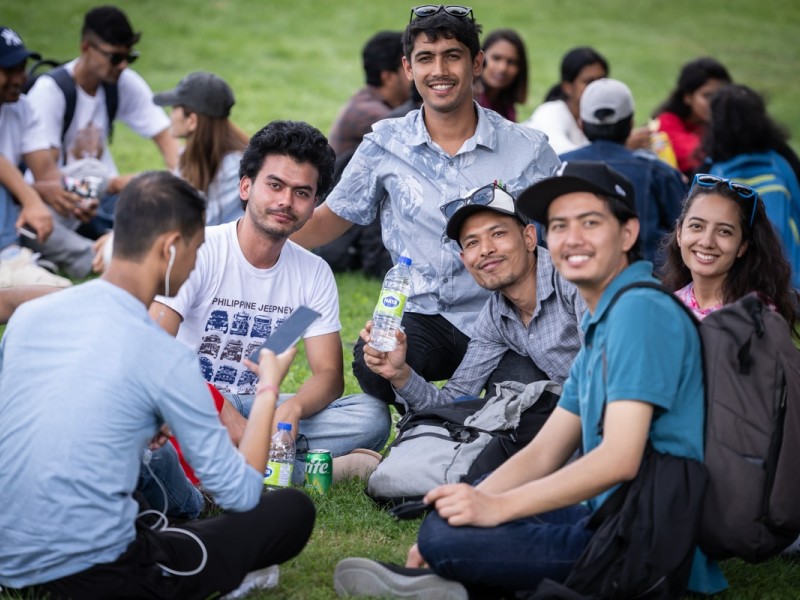 students sitting together on the grass at Fanshawe's orientation