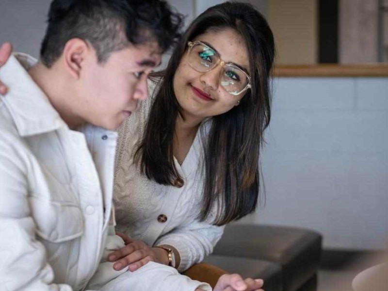 student puts their arm around another student