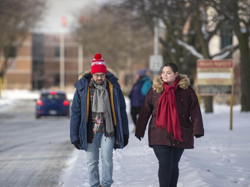 two students walk together at fanshawe in winter