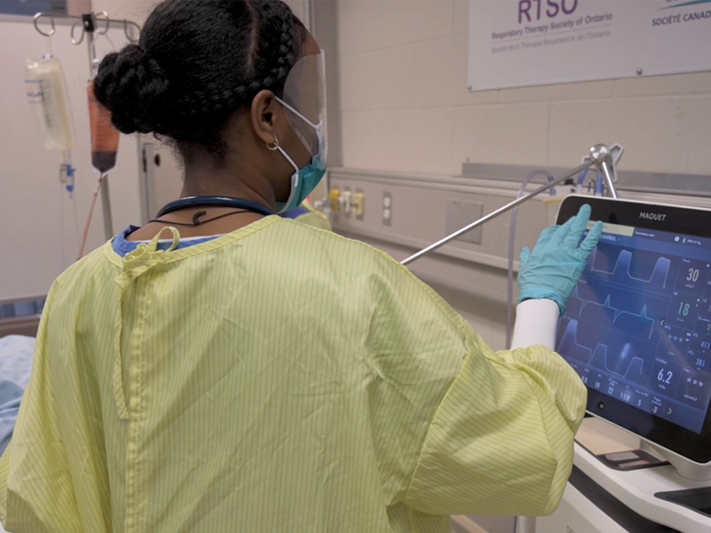 A Respiratory Therapist student works on the screen of a medical ventilator in a simulation lab at Fanshawe College
