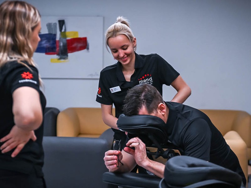 At Fanshawe College's Open House, a prospective student receives a demonstration of massage therapy techniques from a student practitioner, while another student observes.