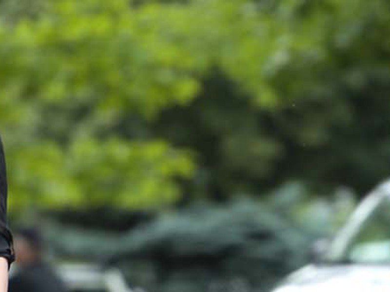 woman wearing sunglasses walking by other people