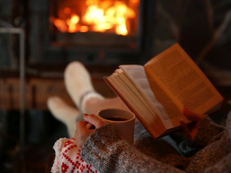 Reading a book near a fireplace