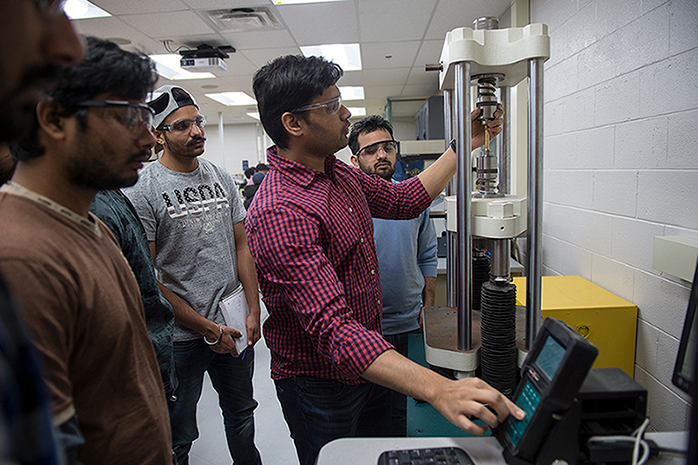 Mechanical engineering students working on equipment