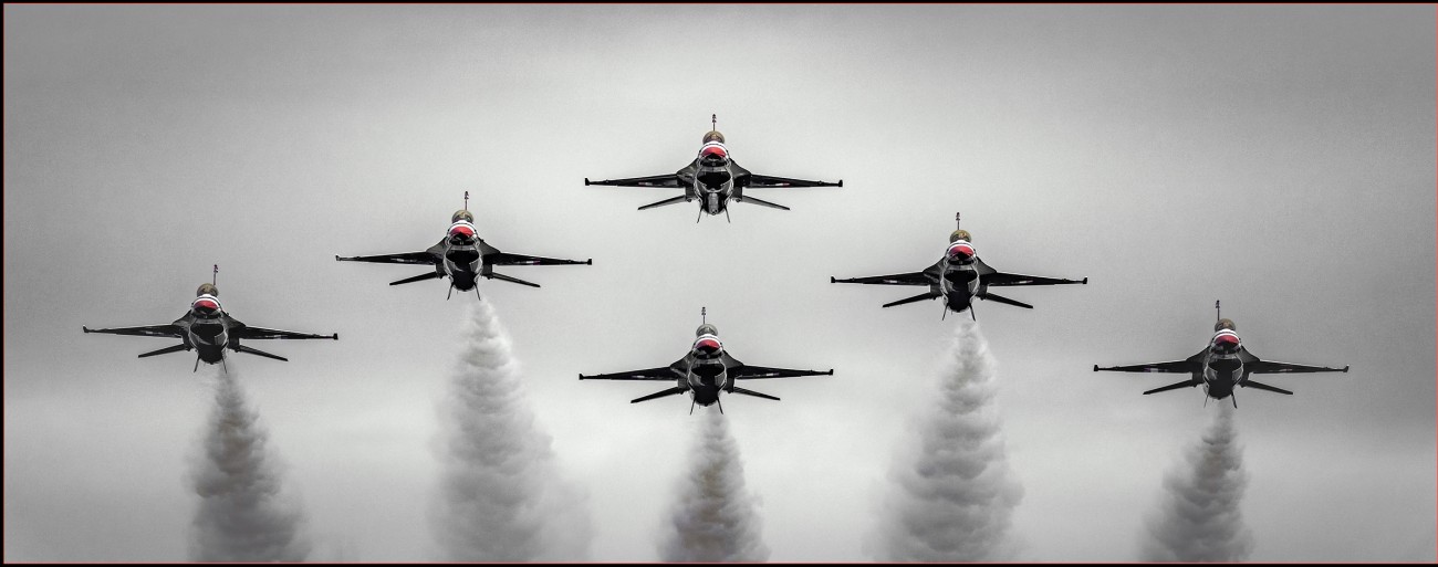A head on view of the USAF Thunderbirds as they fly in perfect formation toward excited onlookers. 
