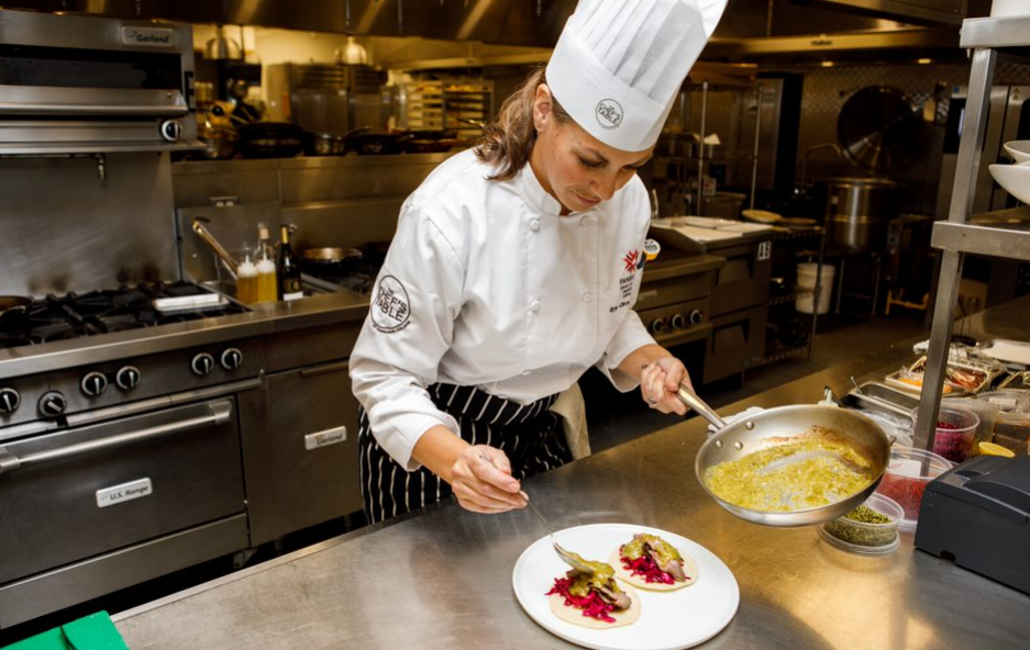 Erin Circelli-Russell  plates a dish in the Chef's Table