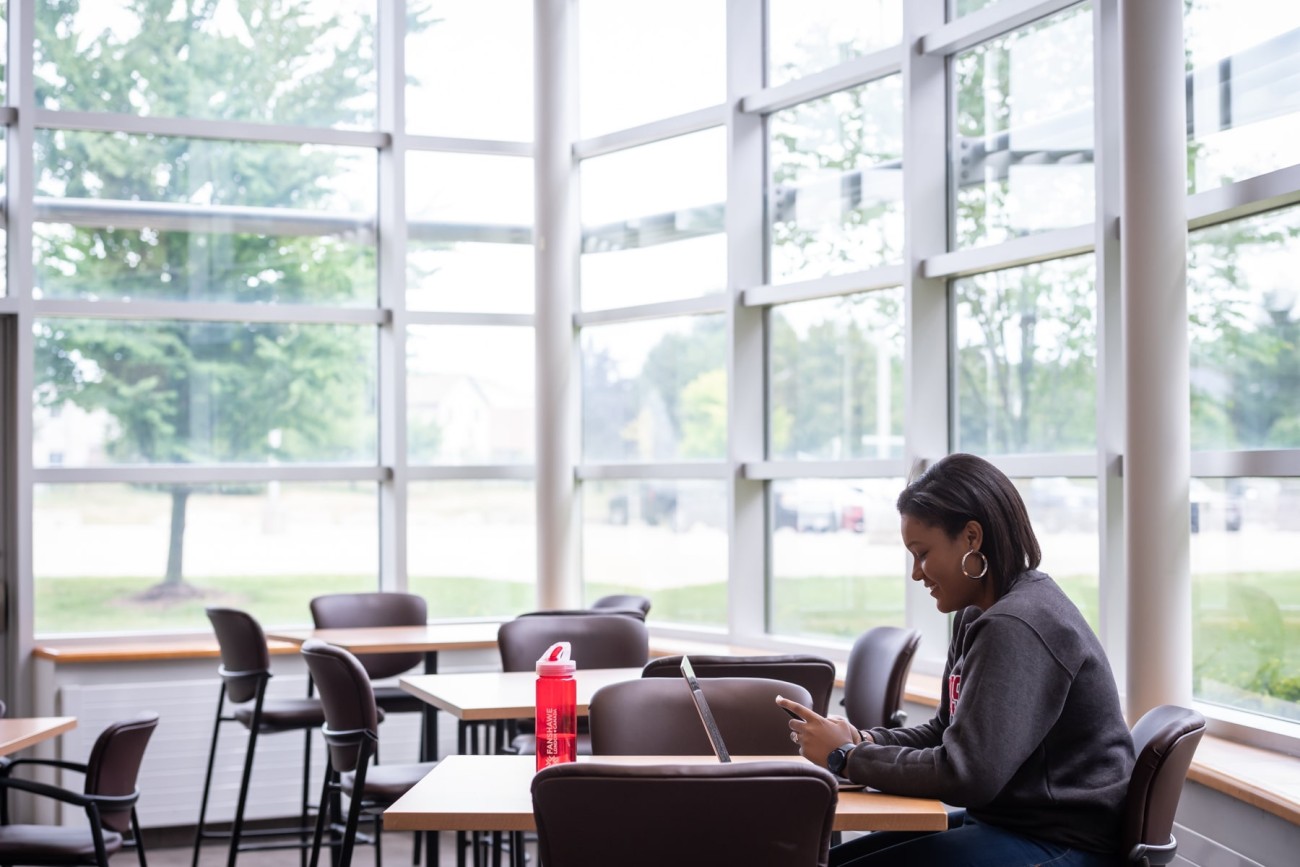 student sits at table in study space in residence