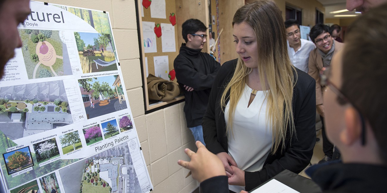 At the London Campus of Fanshawe College, a group gathers around a presentation board showcasing a GIS and Urban Planning project, featuring landscape designs and planting palettes.