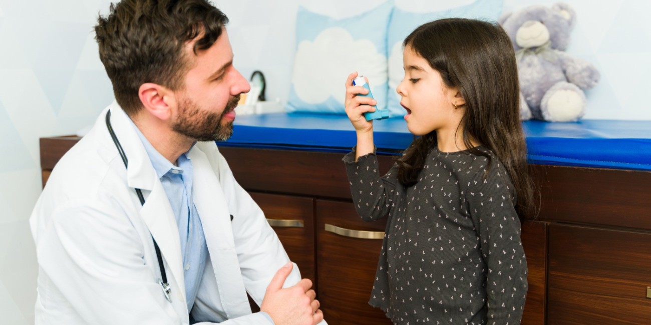 A medical professional works with a young patient to ensure proper use of an inhaler