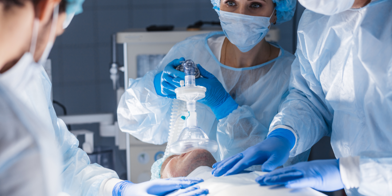 Operating room scene with a patient on the table, two surgeons and an RT working together.