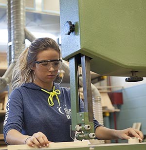 woman wearing safety goggles while working with machinery