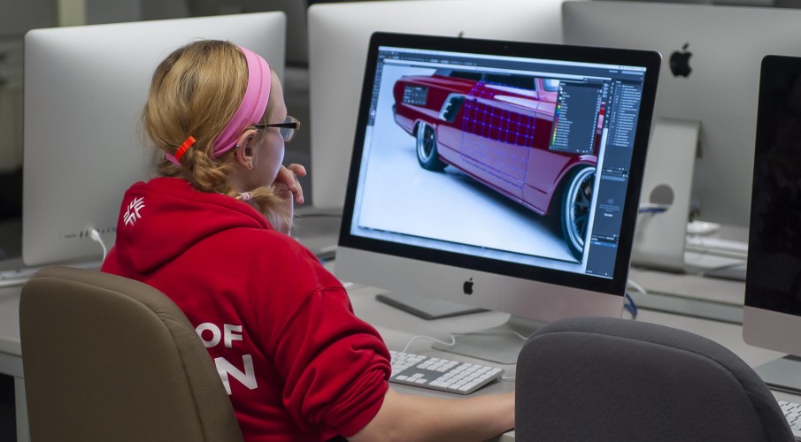 Graphic design student working in computer lab on illustration