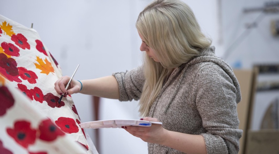 Fine Art student painting tarp in studio