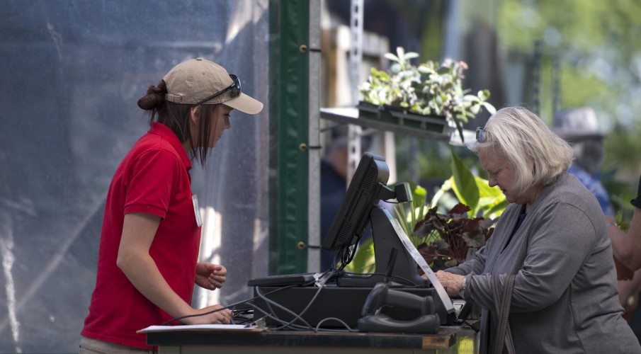 Horticultural student at the checkout with a customer