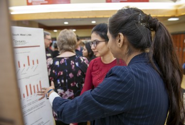 Student showing another person a graph on a presentation