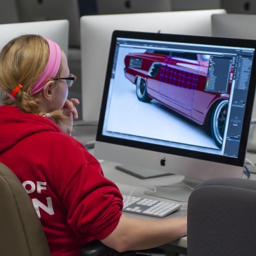 Graphic design student working in computer lab on illustration