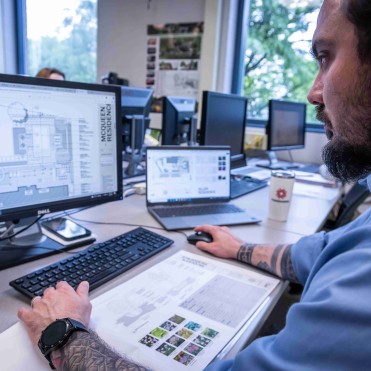 Photo of a student working on a computer rendering of a landscape design