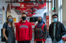 Four masked student standing in a hallway