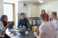 Students gather in the kitchen of an off-campus house