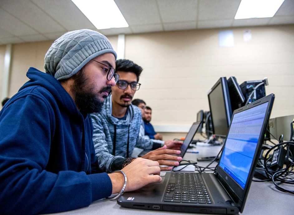 Two guys working on laptop coding
