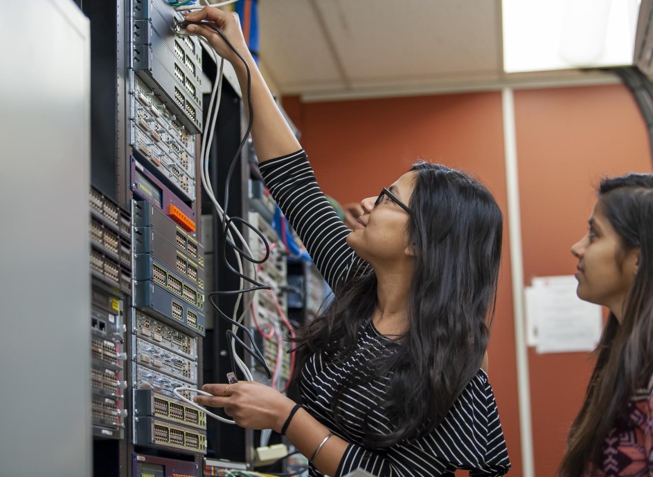 Student changing wires in networking lab