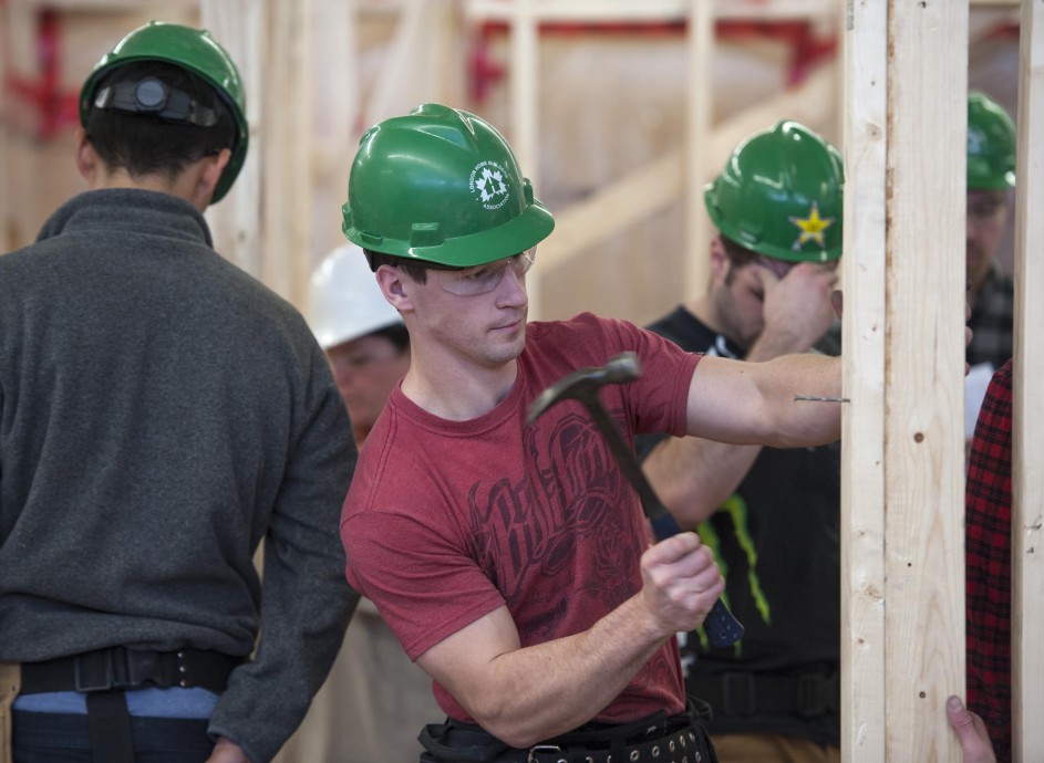 Fanshawe student hammering a nail into frame