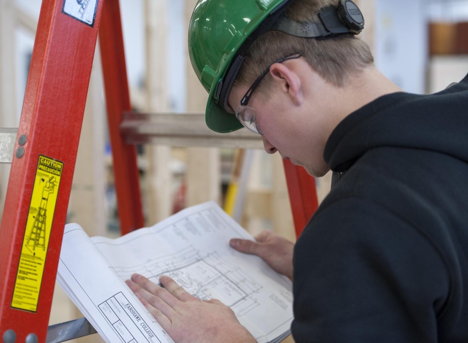 Fanshawe Carpentry student, reviewing plans in workshop