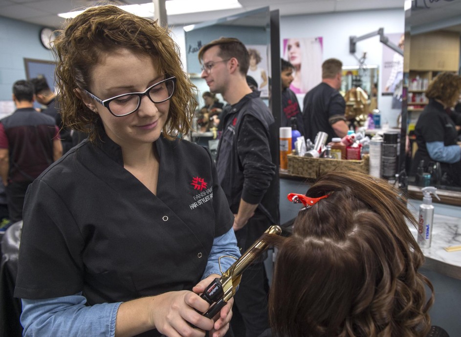 Fanshawe hairstyling student, curling hair of client