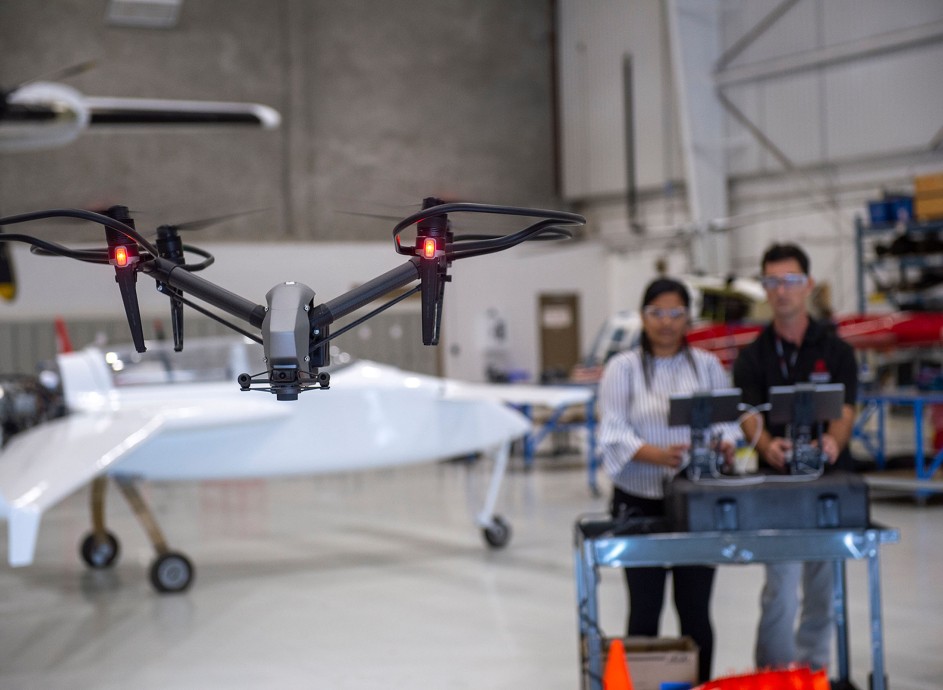 Two students flying a drone inside the Fanshawe hangar space