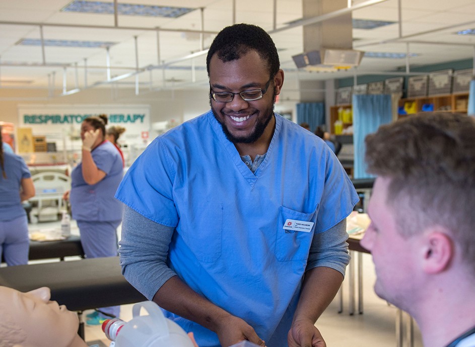 Male nurse student smiling with professor
