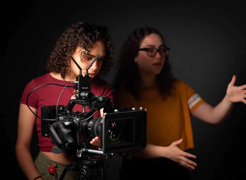 Film students look at a shot through a camera