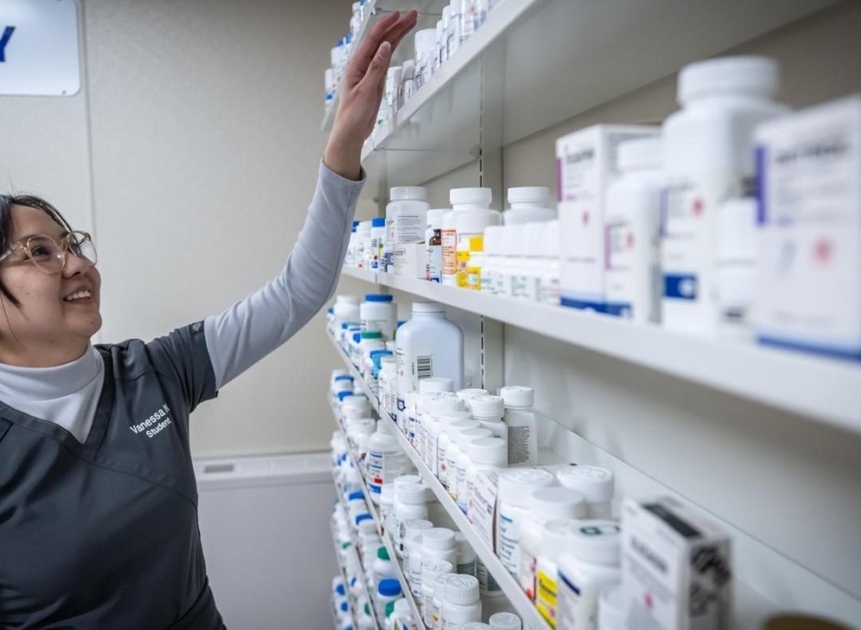 pharmacy assistant student organizes shelves of medication