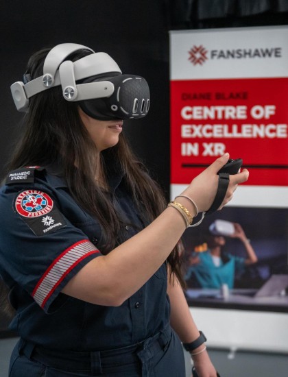t the Fanshawe College London Campus, a Paramedic student wearing a VR headset holds a controller in the Diane Blake Centre of Excellence in XR.