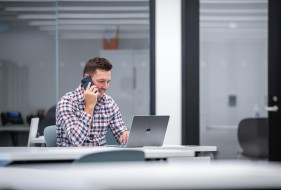 Fanshawe student talking on mobile device while looking at laptop