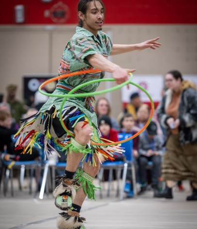person dances in regalia with hoops