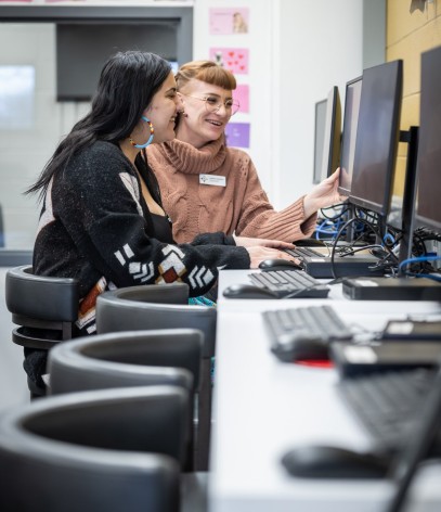 two women sit at computers in the institute of indigenous learning at fanshawe