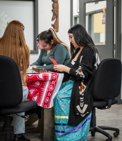 students sit around a table crafting