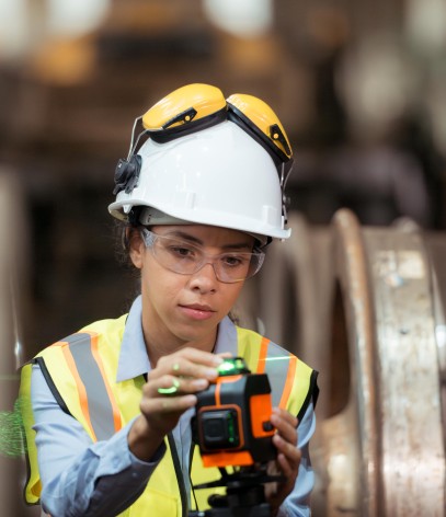 woman in hard hat configures tool