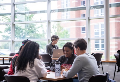 Group of Fanshawe students, playing cards, sitting in common area