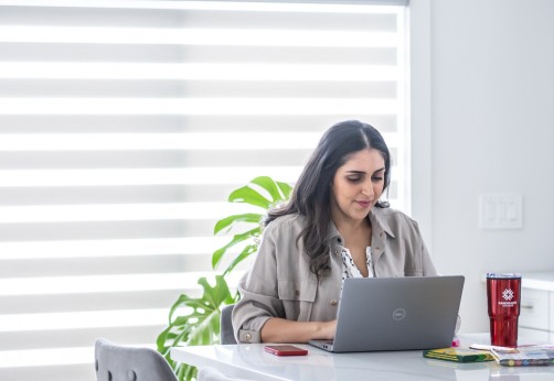Student sitting in their home working on their laptop
