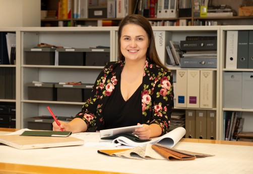 Photo of a design student posing at their desk during a co-op term