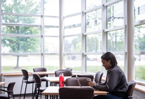 student sits at table in study space in residence
