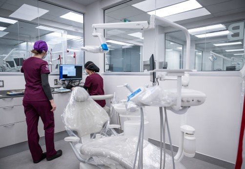two dental workers stand in oral health clinic