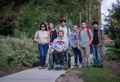 A group of Fanshawe students posing for a photo on a path filled with greenery